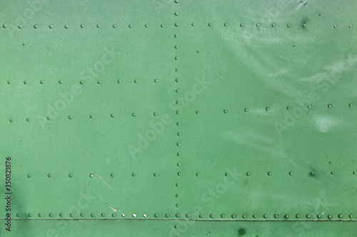 Old aircraft green painted aluminum texture with rivets.