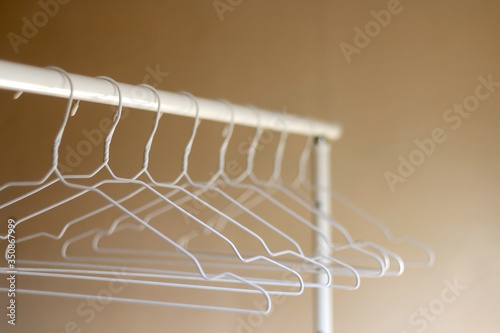 White empty hangers on a clothing rack. Selective focus. 
