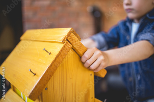 Young boy assembling a birdhouse