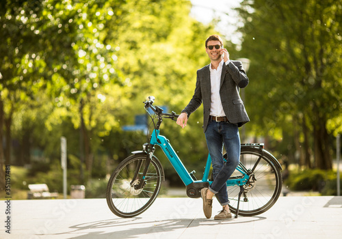 Young businessman on the Kettler Quadriga CX10 ebike with mobile phone