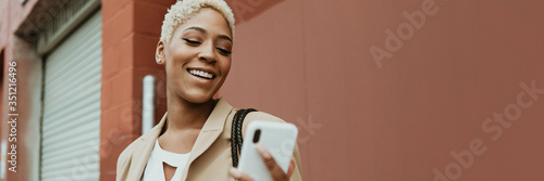 Happy black businesswoman using her smartphone