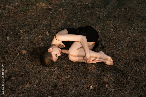 a girl is resting in the middle of the forest, lying on the ground