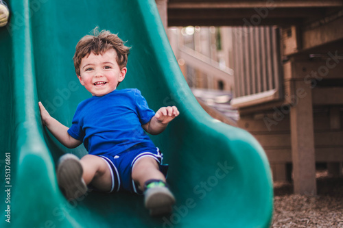 boy on playground slide in marco island mackle park 