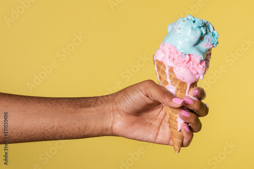 Hand holding a melting ice cream