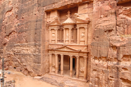 View of temple Al-Khazneh (The Treasury) carved in red sandstone rock in ancient Petra city in Jordan. There is no people in front of monument. Beautiful landscape. Travel theme.