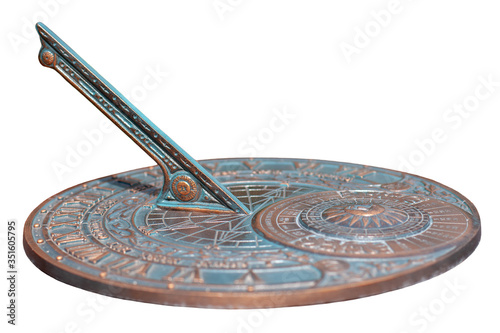 Antique sundial with a beautiful dial and ornament isolated on white background. The bronze oxidized disk. Selective shallow focus on the center of the disc.