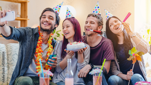 Young group of happy friends celebrating birthday and making selfie photo