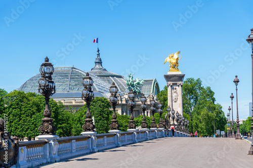 People walking on Pont Alexandre III with the Grand Palais in the background during Coronavirus epidemic - Paris, France