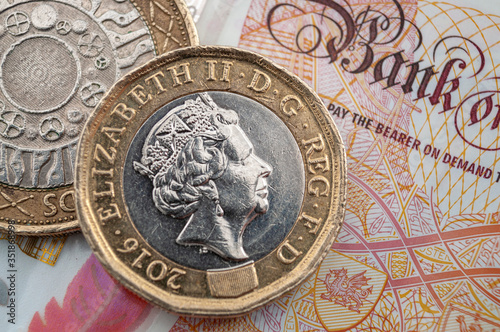 Business and finance, British economy and currency exchange concept with macro close up on one pound and two pounds coins and 10 GBP bank note