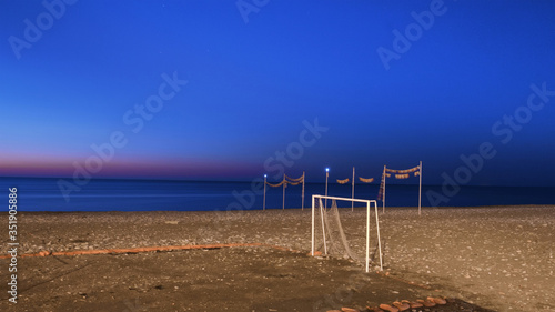 Old football goal on the sand at the beach with night sky background