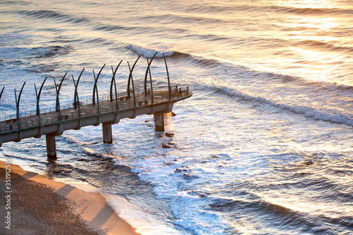 View of the Indian Ocean through the Millennium Pier in Umhlanga Rocks at Sunrise. Durban, South Africa.