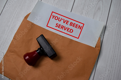 Red Handle Rubber Stamper and You've Been Served text isolated on the table.