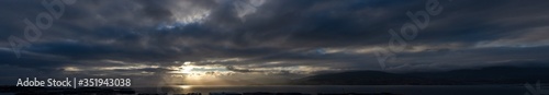 Panoramic storm sky with a spotlight
