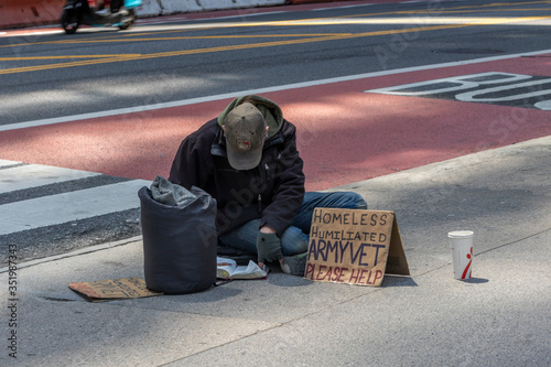 New York, USA - MAY 10, 2020: A homeless man sitting on the street asking for help