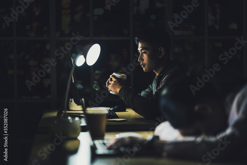 Asian businessman working hard late with his technology laptop in office