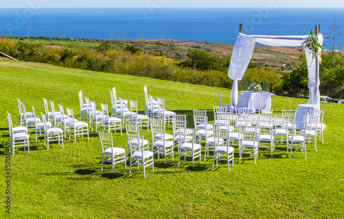 Chaises blanches sur pelouse pour mariage 