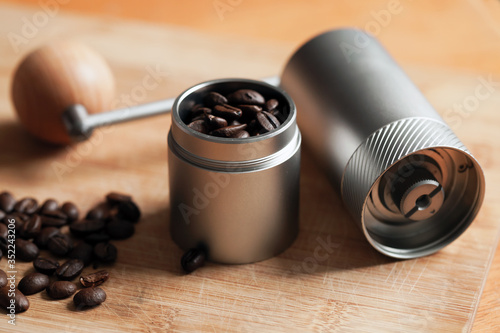 Modern manual coffee grinder and roasted coffee beans