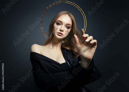 Portrait of blond sexy woman with long hair halo nimbus over her head on black background. Perfect girl with nimb, beautiful eyes, nice clean skin, beautiful natural makeup, long hair, saint girl