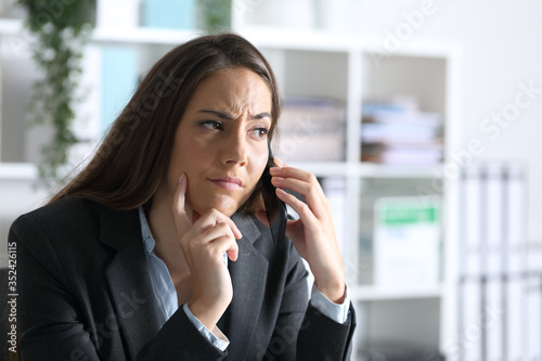 Suspicious executive calling on smart phone at office