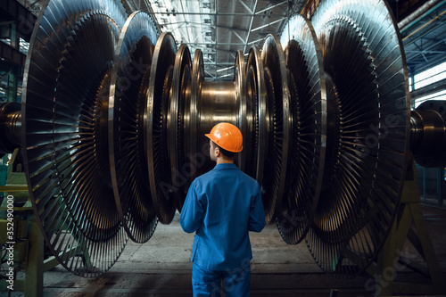 Worker checks turbine impeller vanes on factory