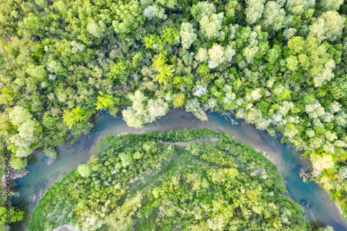 Flight through majestic river and lush green forest at sunset time. Landscape photography