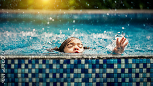 Baby girl drowning in pool. Danger and children Concept. Pools and swimming lessons.