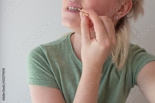  Girl brushes her teeth with a toothpick after eating