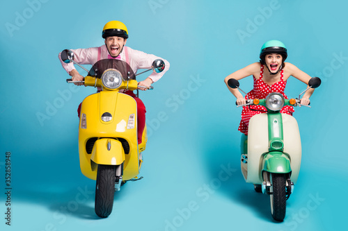 Portrait of his he her she nice attractive cheerful glad ecstatic crazy overjoyed couple riding moped having fun fast speed isolated on bright vivid shine vibrant blue color background