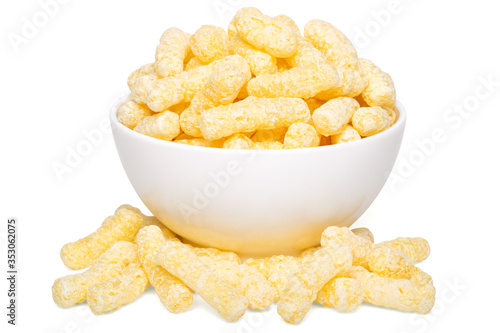 A heap of corn snacks. Sweet sticks of puffcorn. Dry breakfast in white bowl