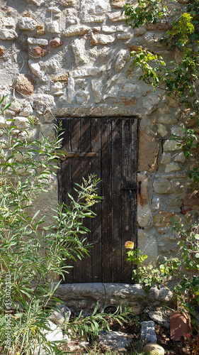 Stare zniszczone drewniane drzwi do piwnicy w winnicy w Prowansji we Francji.