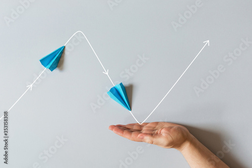 concept of small business support. graph of of economic crisis, stagnation and recovery with help of state. paper plane flies up, falls down