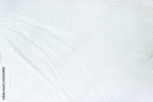 Top view of white fabric bed sheet texture background.
