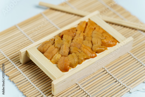 Japanese sea urchin in wooden tray , sushi and sashimi ingredients