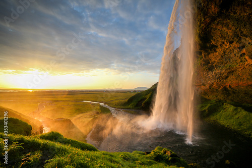 Waterfall Selandjafoss Iceland at sunset or sunrise. Beautiful waterfall in Iceland. Golden hour. Cave and waterfall. Travel in Iceland. Beautiful sky against the big waterfall. inside the water. 