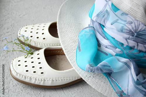 White women's shoes, a summer hat and a delicate scarf, an image for summer.