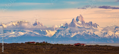 majestic Torre and Fitz Roy Mountains, and red ranch, by the lake, in a sunny day.