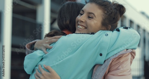 Two happy teen girls hugging and walking