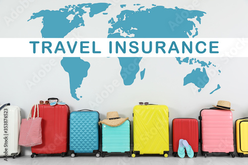 Colorful suitcases and phrase TRAVEL INSURANCE on light background