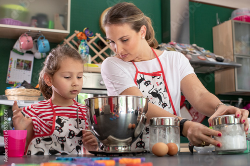 Una mamma prepara dei dolci in cucina insieme alla figlia