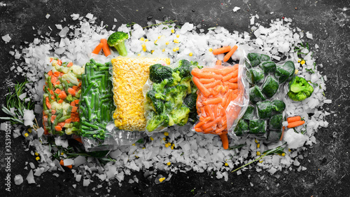 Assortment of frozen vegetables on ice. Stocks of food. Top view. Free space for your text.