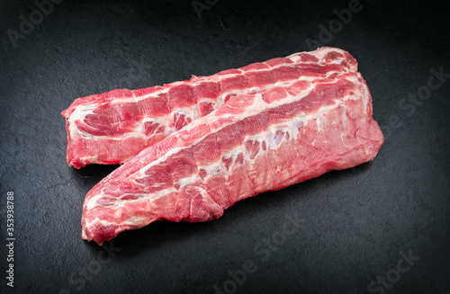 Raw pork spare loin ribs St Louis cut offered as closeup on black background with copy space