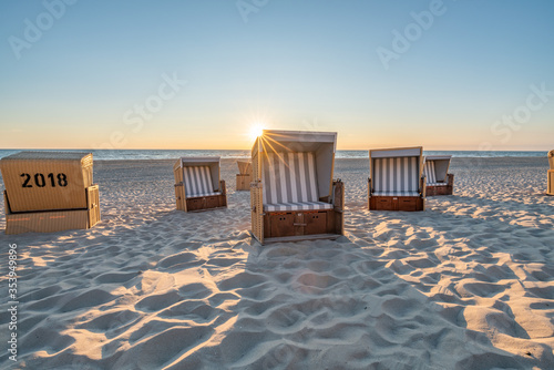 Roofed wicker beach chairs at the North Sea coast on Sylt, Germany 