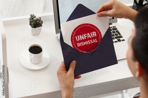 Young man with envelope in office. Concept of unfair dismissal