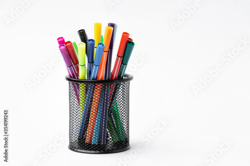 Color pen in black metal container on white background