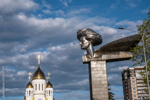 Monument to the revolutionary Olga Genkina and the dome of the Orthodox Church on the forecourt in Ivanovo, Russia.