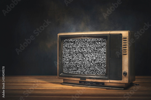 Vintage old TV set is still life with static screen in the dark room.