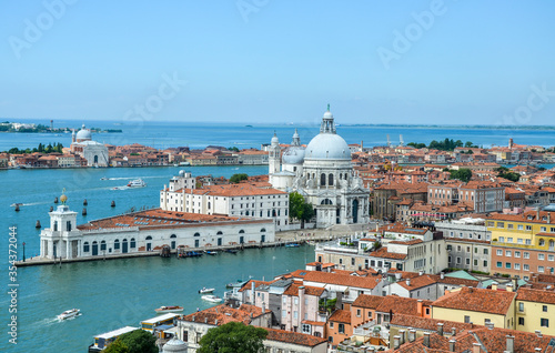 Aerial view of the red tiled roofs, Mediterranean Sea and Basilica Santa Maria della Salute standing at the entrance to The Grand Canal in Venice, Italy