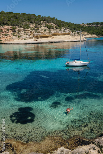 couple next to a moored sailboat, Cala Portals Vells, Calvia, Mallorca, Balearic Islands, Spain