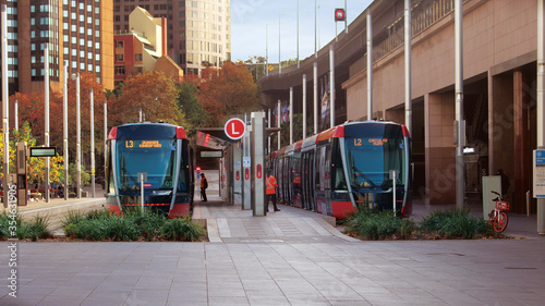Streetscape outside Circular quay light rail station. Pictured are two light rail trains.
