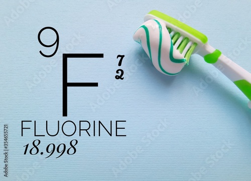 Fluorine is a chemical element of the periodic table with the symbol F and atomic number 9. The symbol F with atomic data and a brush with fluoride toothpaste.